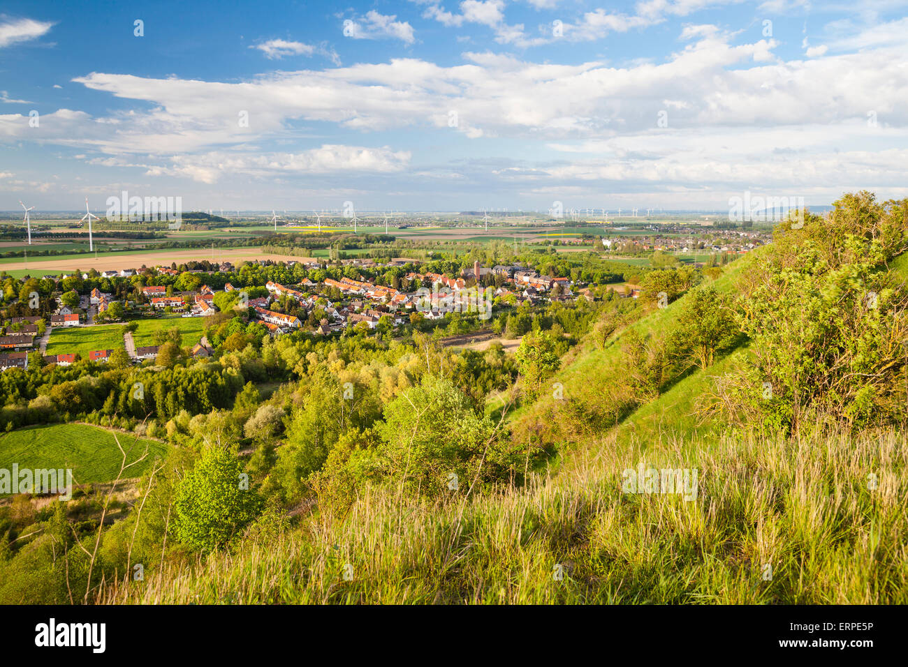 Blick von einer Halde über flache westdeutsche Landschaft in der Nähe von Aachen mit vielen Windkraftanlagen und einige Wolken am blauen Himmel. Stockfoto