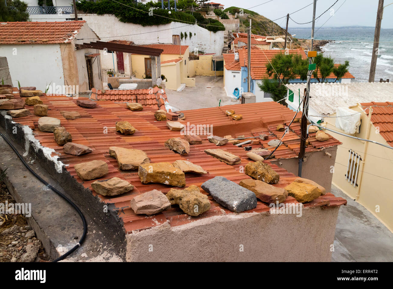 Felsen um das Dach zu halten in der Nähe der Küste in Mega Limnionas auf der Insel Chios, Griechenland, Häuser, Stockfoto
