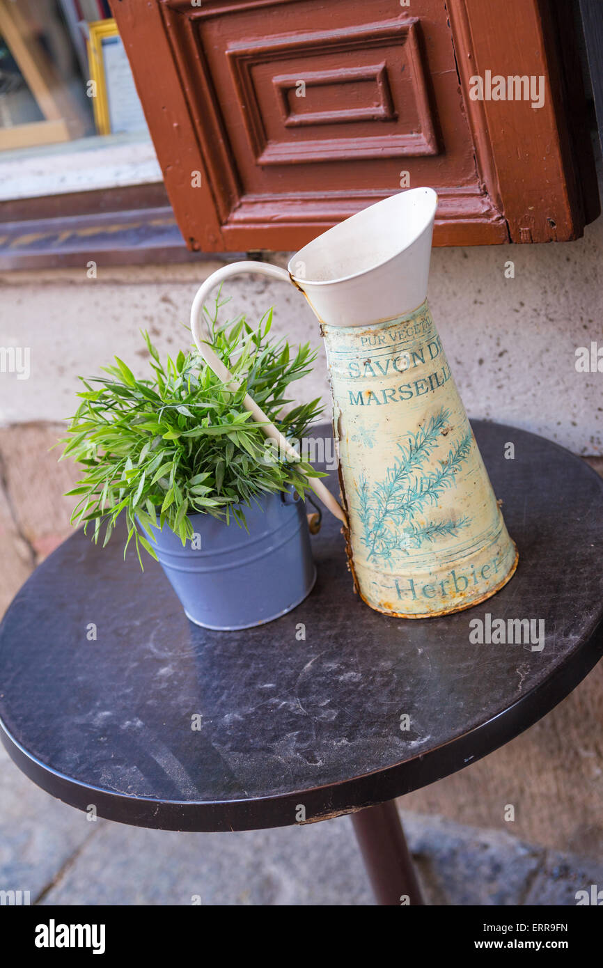 Stillleben mit Vase und Grünpflanze stehen auf einem Tisch in der Nähe einer verzierten Fenster Stockfoto