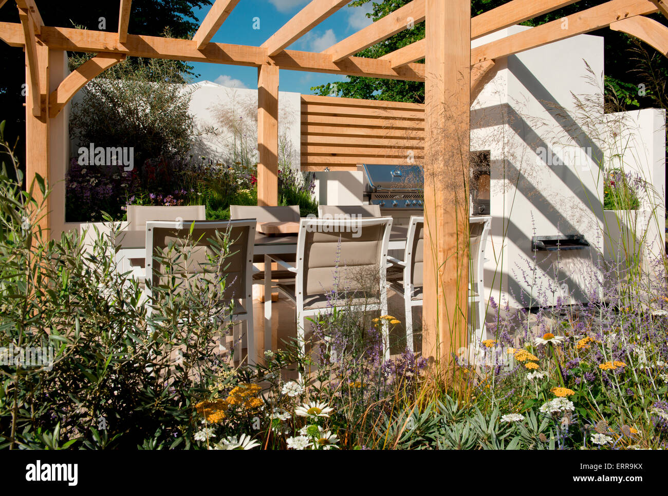 Sitzgelegenheiten und eine Außenküche unter einer Pergola in der Al-Fresco-Garten von The Hampton Court Flower Show, 2014 Stockfoto