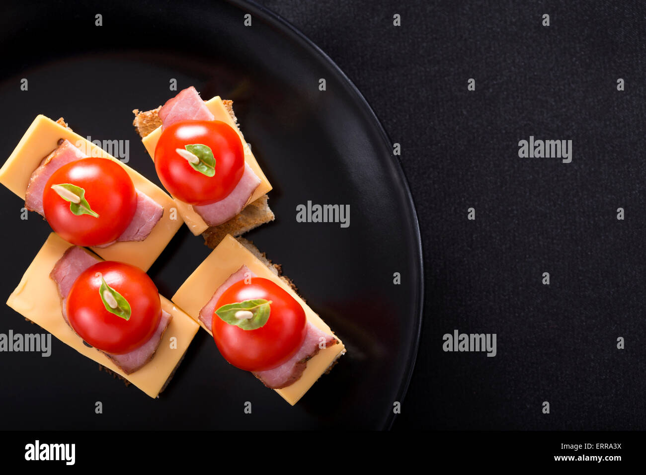 Toast mit Käse und Schinken auf einem dunklen Teller Stockfoto