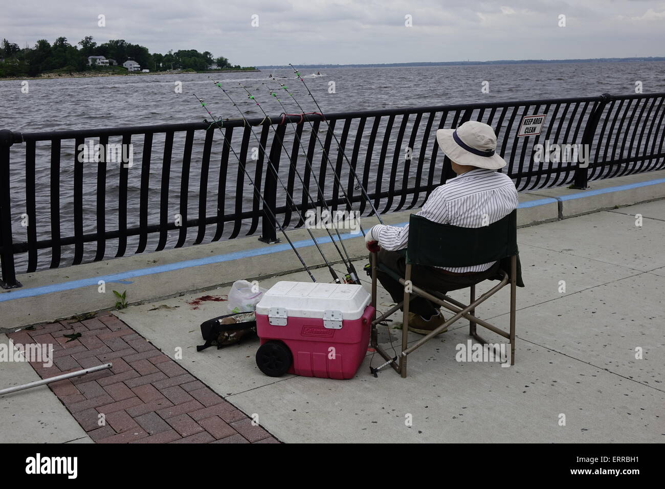 Ein Angler wartet auf einen Biss auf der Promenade in Keyport Waterfront Park, New Jersey Stockfoto