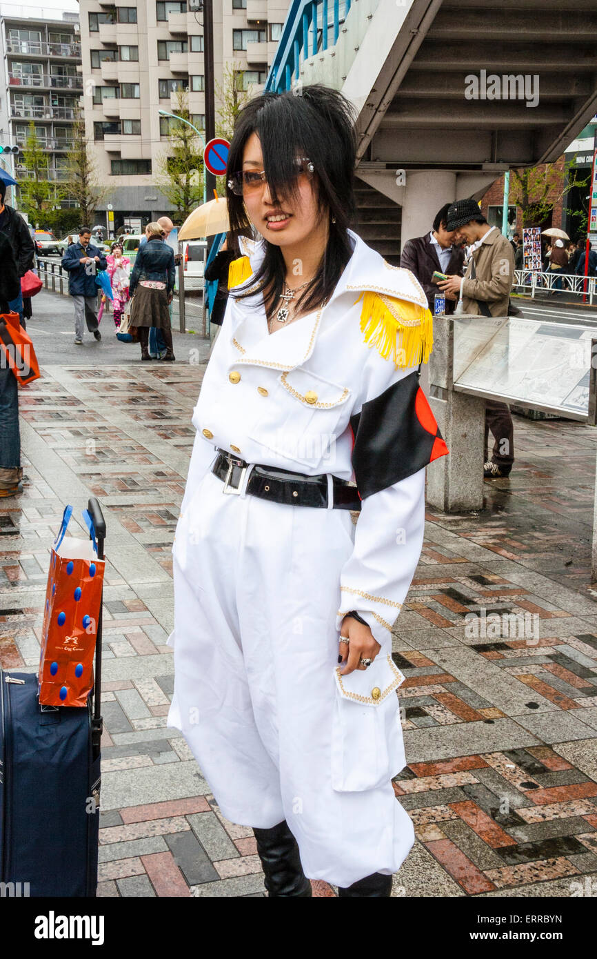 Junge japanische Frauen kleideten sich in weißer Militäruniform mit schwarzem Armband, posierte in der Straße in Harajuku, Tokio. Augenkontakt. Stockfoto
