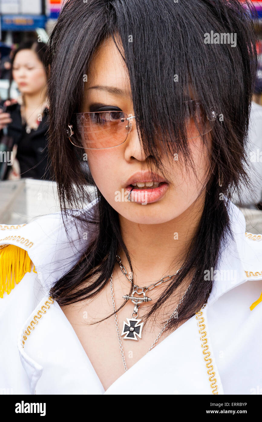 Nahaufnahme von Kopf und Schulter japanischer junger Frauen, die sich in einer Uniform im weißen Militärstil bekleidet haben und ein eisernes Kreuz um den Hals tragen. Harajuku, Tokio. Stockfoto