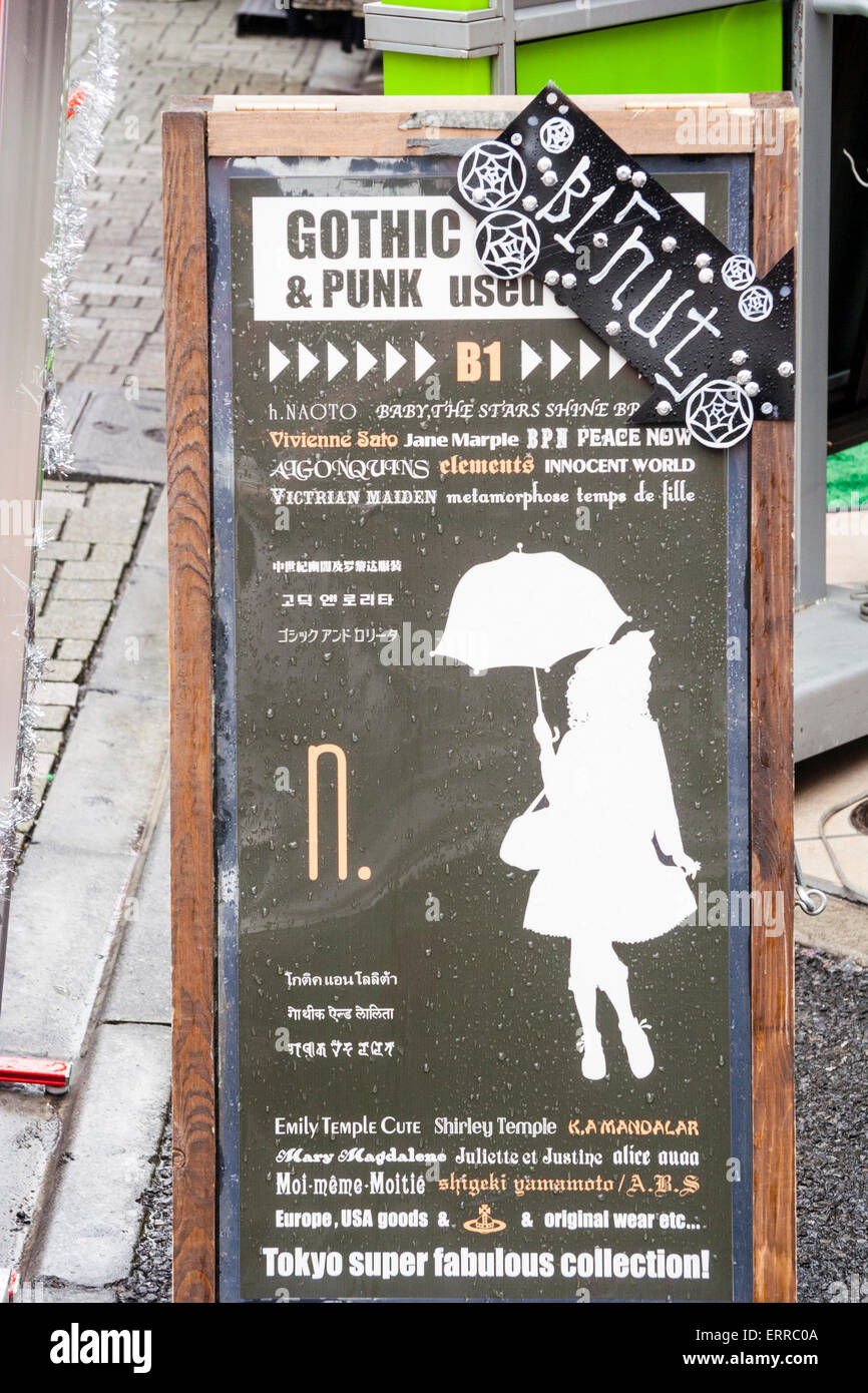 Japan, Tokio, Harajuku. Brett auf Straßenpflaster für Gebrauchtkleiderladen, das Kleidung im Stil der Gotik und Lolita verkauft. Stockfoto