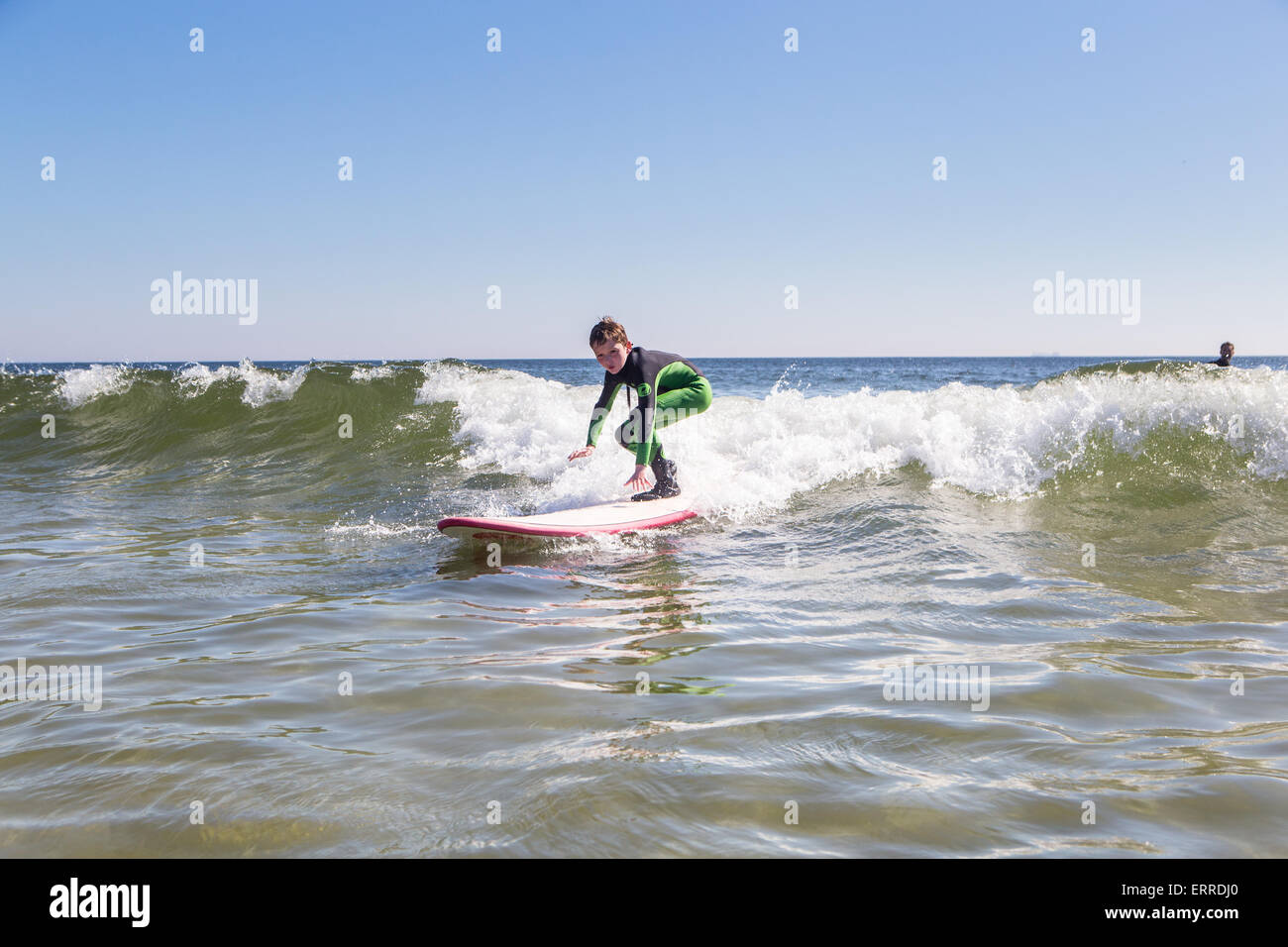 kleiner Junge im Neoprenanzug Surfen Stockfoto