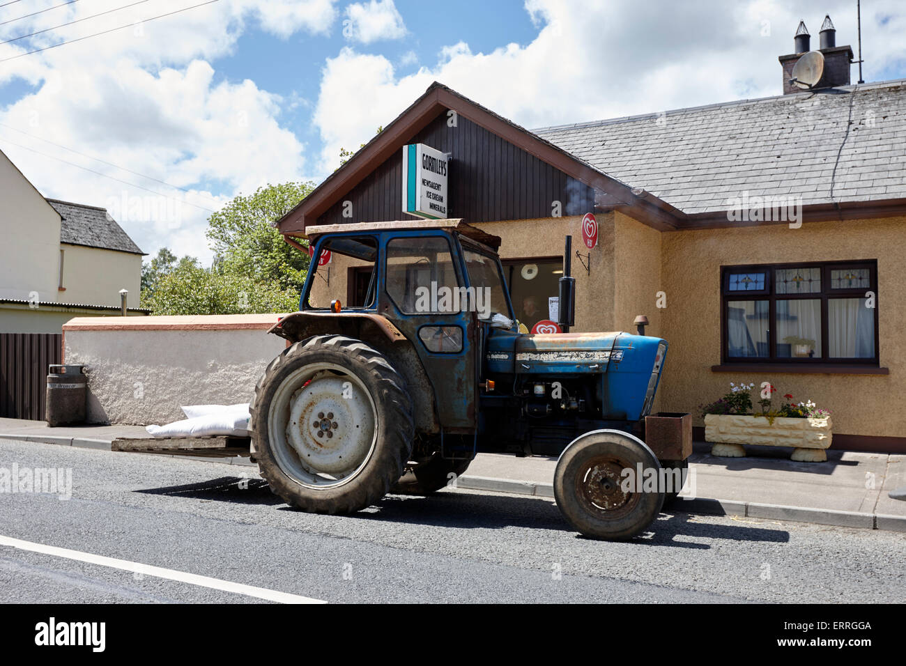 Alter Traktor geparkt vor einem lokalen Geschäft in einem kleinen Dorf im ländlichen Irland Emyvale monaghan Stockfoto