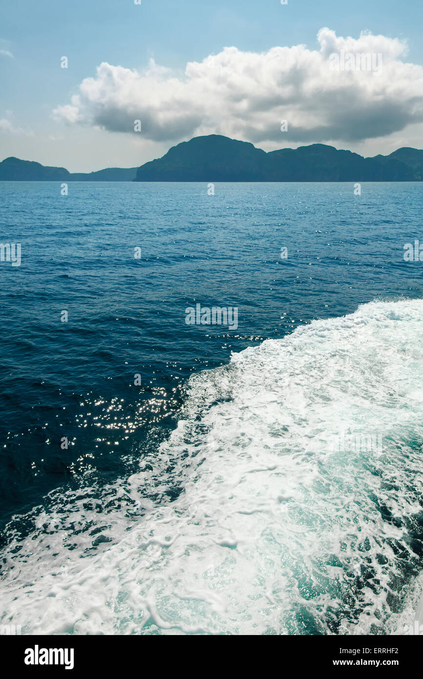Wasserweg nach Motorboot auf tropischen Meer mit großen weißen Wolke am blauen Himmel Stockfoto