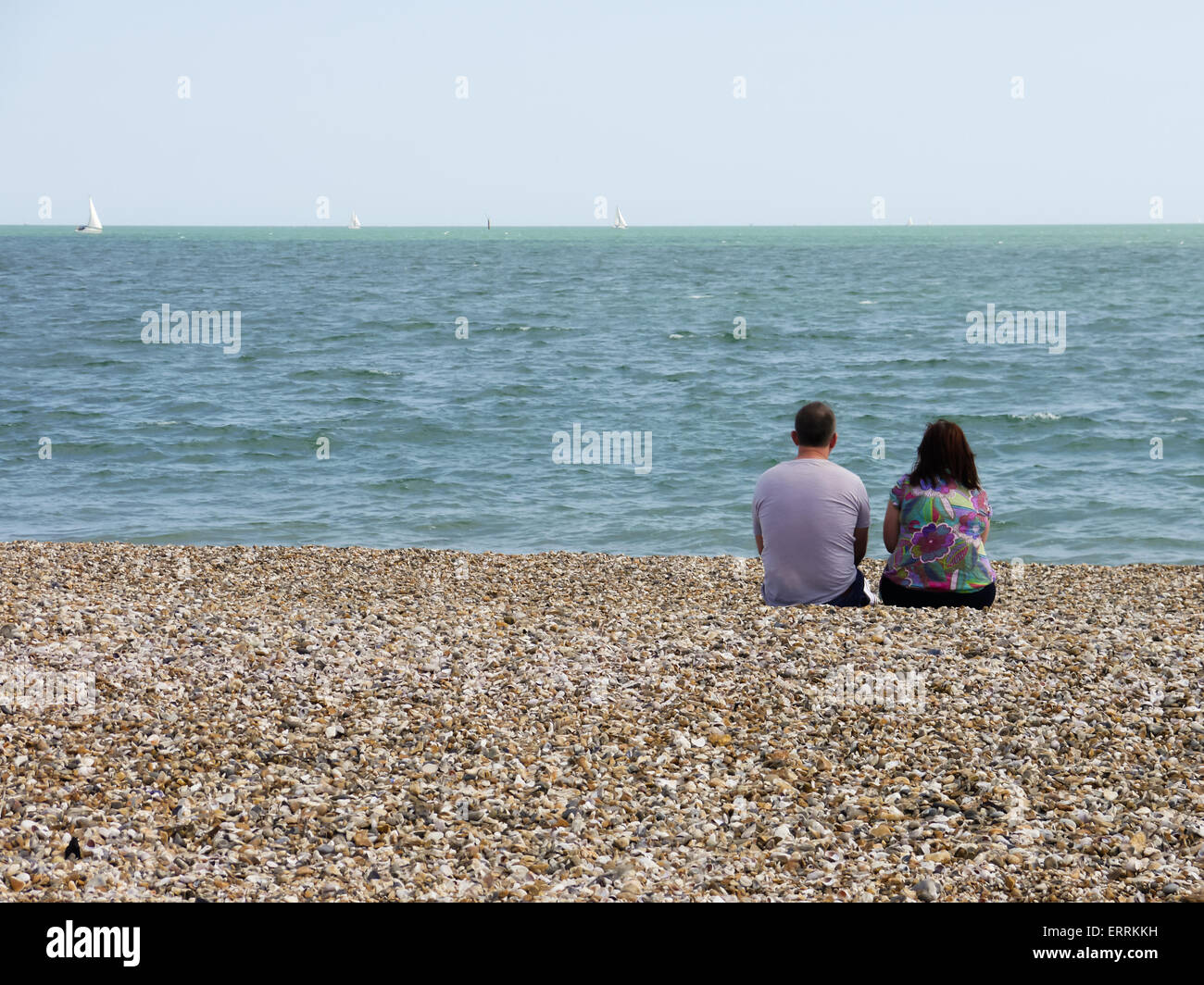 Ein paar sitzen am Strand, das Meer zu beobachten. Stockfoto