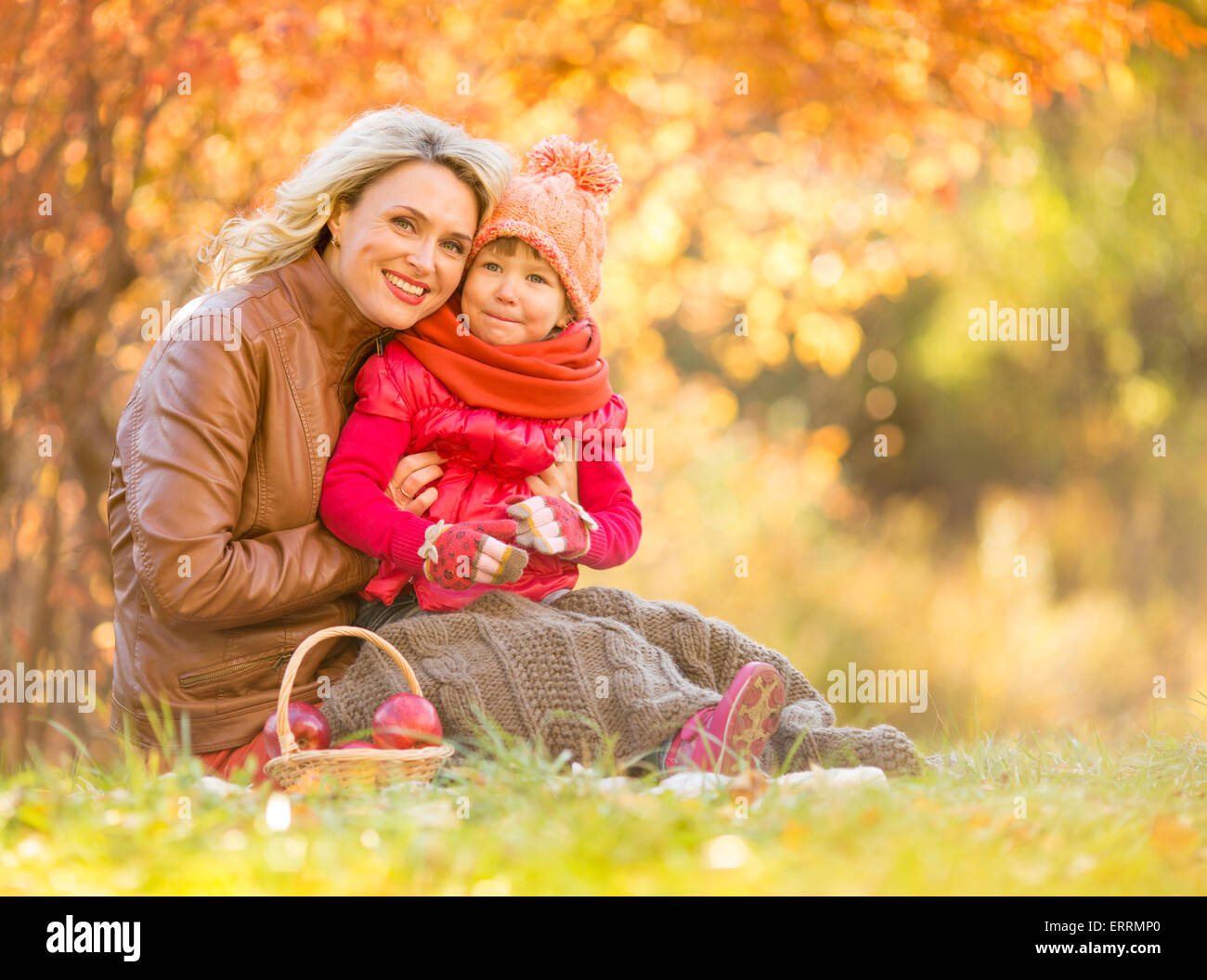 Glückliche Mutter und Kind sitzt im Freien im Herbst Stockfoto