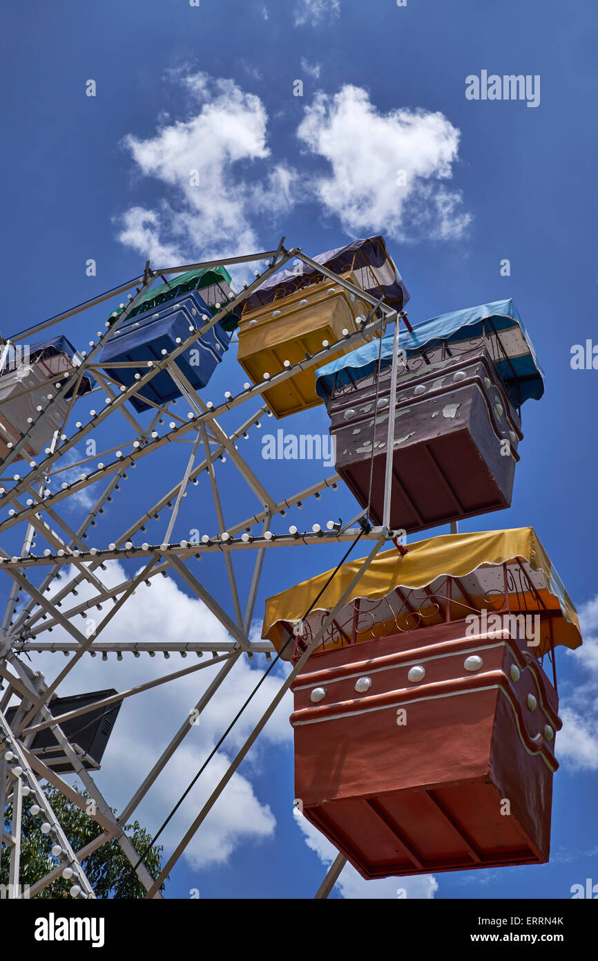 Riesenrad. Fahrwagen mit großen Rädern. Fahrt auf dem Festgelände vor einem blauen Sommerhimmel. Lustige, faire Fahrt Stockfoto