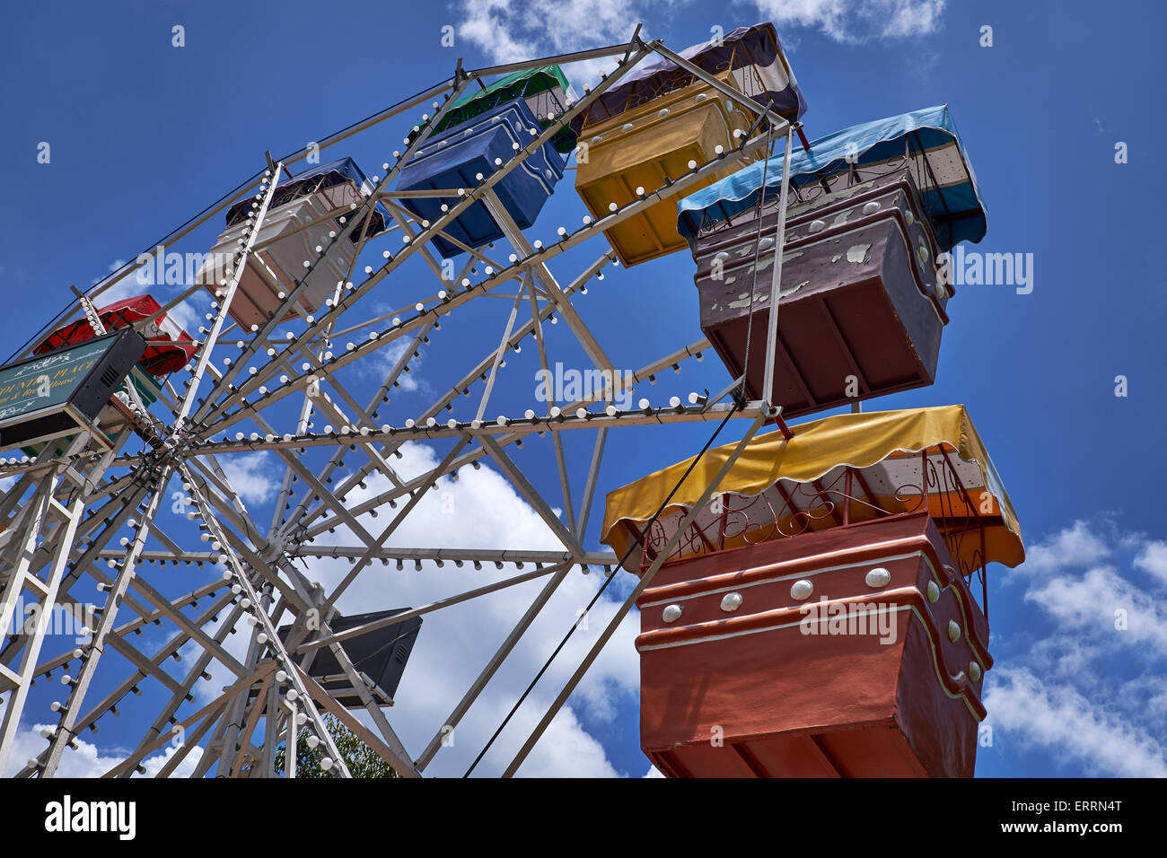 Riesenrad. Fahrwagen mit großen Rädern. Fahrt auf dem Festgelände vor einem blauen Sommerhimmel. Lustige, faire Fahrt Stockfoto