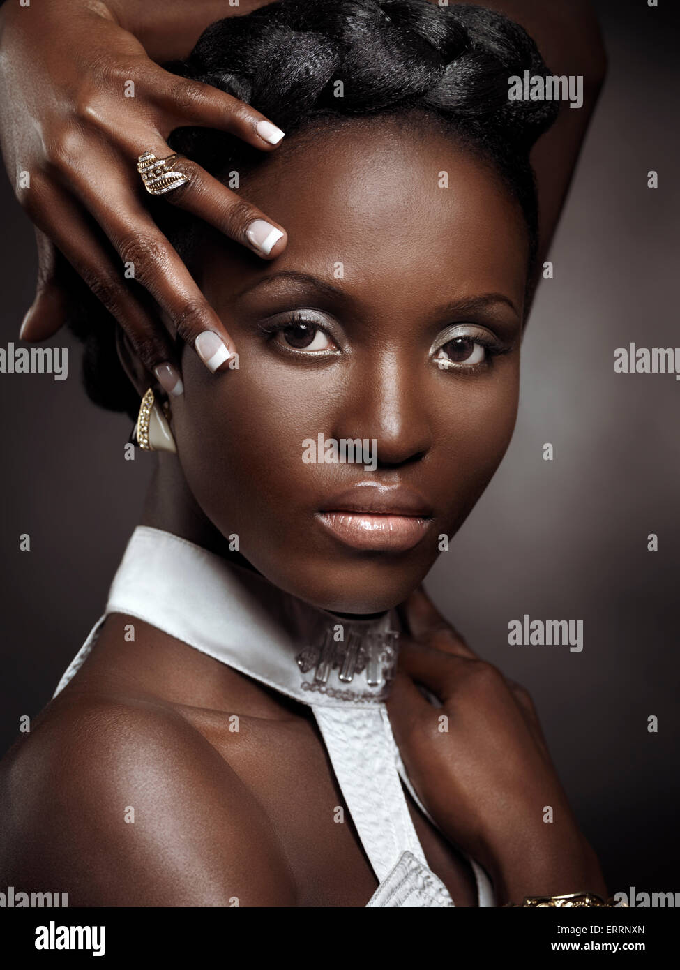 Führerschein und Fingerabdrücke bei MaximImages.com - wunderschöne junge afroamerikanische Frau mit großen Haaren, die Schmuck trägt, künstlerisches Schönheitsporträt auf Braun Stockfoto
