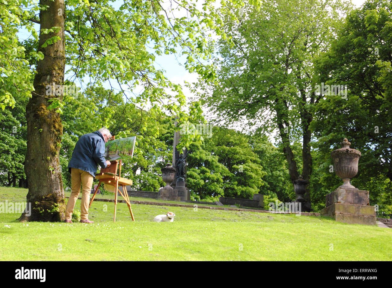 Beobachtet von seinem Hund, fängt ein Maler die Schönheit der Pisten, einem begrünten Hügel in Buxton Derbyshire England UK Stockfoto