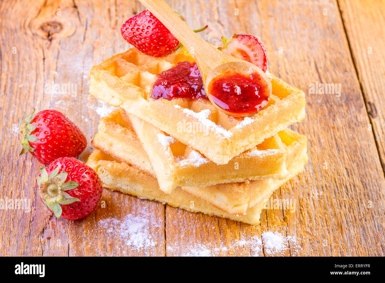 hausgemachte Waffeln mit Ahornsirup Erdbeeren auf hölzernen Hintergrund Stockfoto