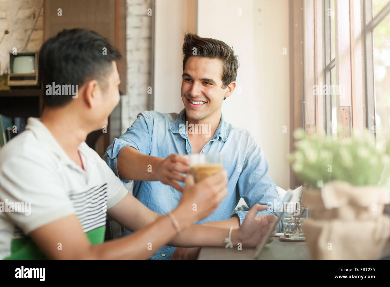 Zwei Männer Cheers Toast Drink Freunde Jungs glücklich Lächeln sitzen Stockfoto