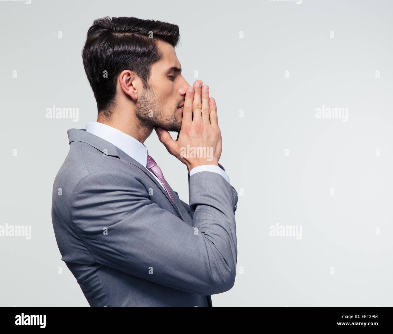 Seite Ansicht Porträt Ofa Geschäftsmann Heilungsgebet grauen Hintergrund Stockfoto