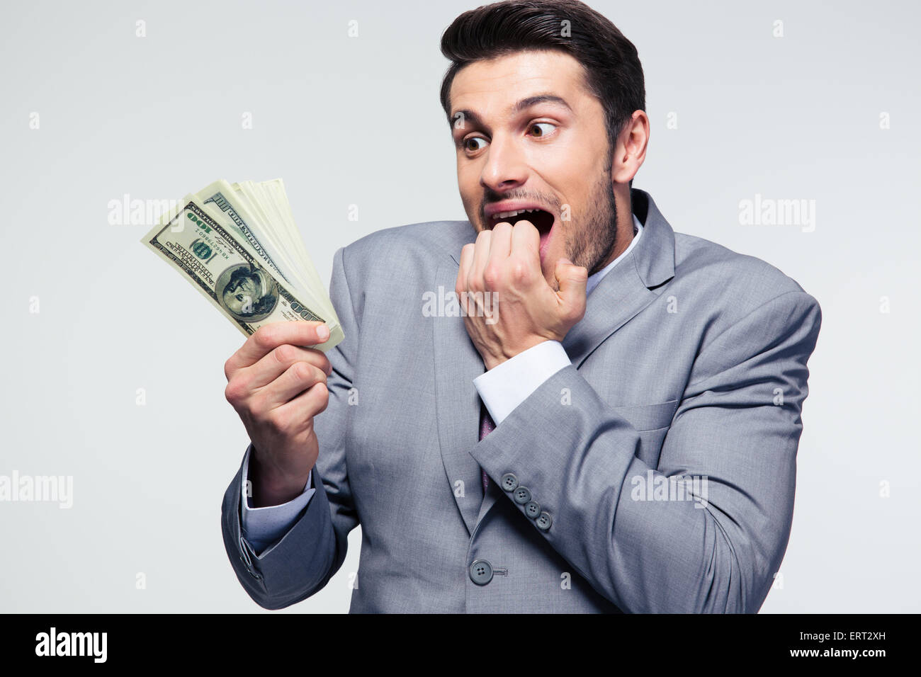 Gut aussehend Geschäftsmann mit US-Dollar auf grauem Hintergrund Stockfoto