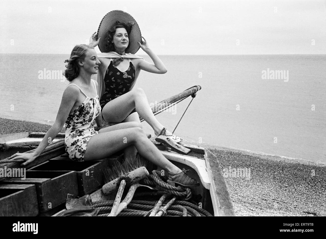 Frauen in ihren Kostümen Baden in einem Fischerboot entlang der Küste, Hastings, ca. 1945. Stockfoto