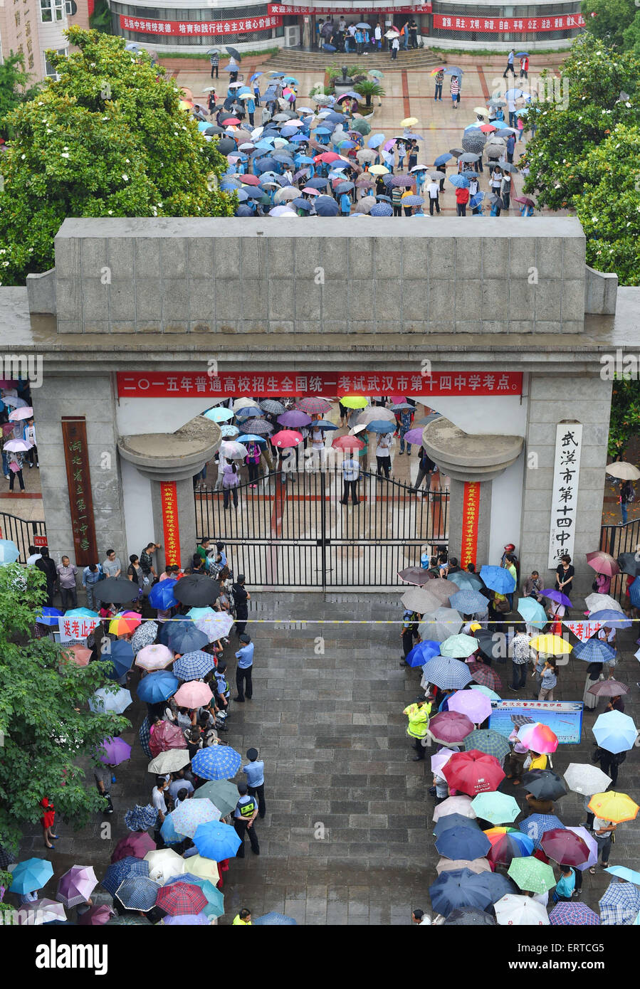 Wuhan, Hubei, China. 7. Juni 2015. Kandidaten eine Prüfung zu beenden und Fuß aus Nr. 14 Middle School in Wuhan als ihre Eltern halten Sie Sonnenschirmen draußen warten. Insgesamt 9,42 Millionen chinesische Schülerinnen und Schüler fing '' Gaokao'', die jährlichen nationalen College-Aufnahmeprüfung gestern. Der Test nennt man oft einen '' Kampf um Schicksal zu bestimmen '' wie seine Ergebnisse entscheiden, ob ein Student aufs College, zurück in die Schule um ein weiteres Jahr geht oder versucht, einen Job zu finden. © SIPA Asien/ZUMA Draht/Alamy Live-Nachrichten Stockfoto