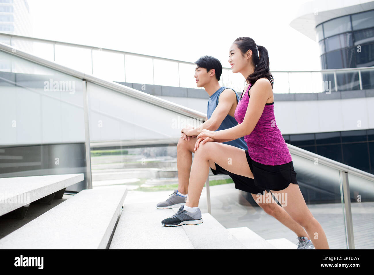 Junges Paar stretching Beine auf Treppe Stockfoto