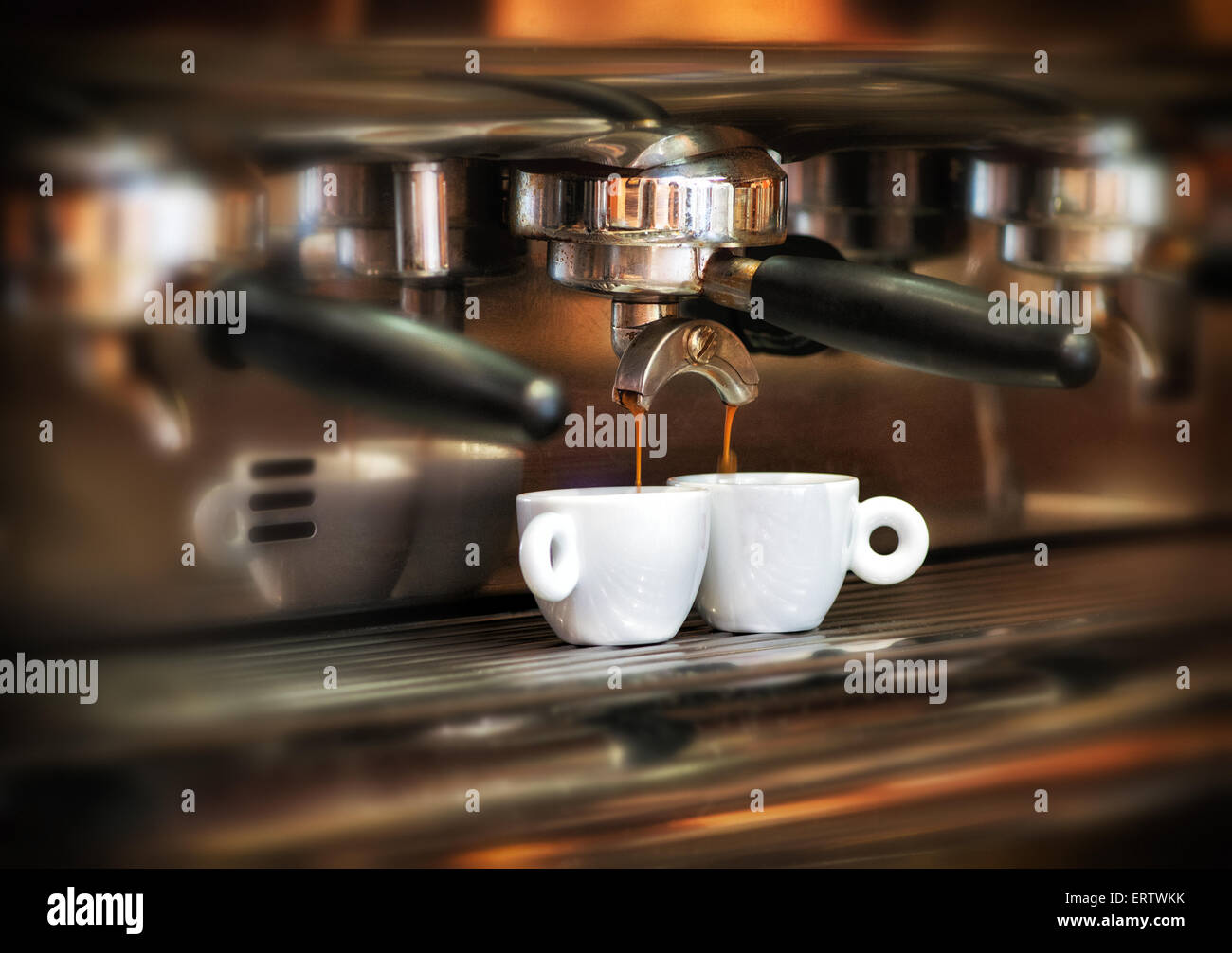 Italienische Espresso-Maschine auf einen Zähler in einem Restaurant Abgabe frisch gebrauten Kaffee in zwei kleine Tassen Stockfoto