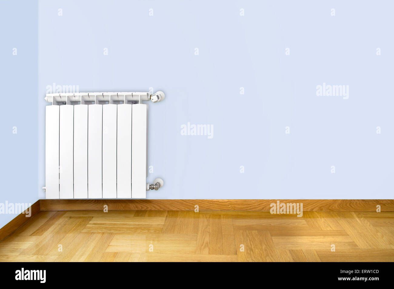 Weiße Heizkörper an blauen Wand und Holzparkett Stockfoto Weiße Heizkörper an blauen Wand und Holzparkett Stockfoto