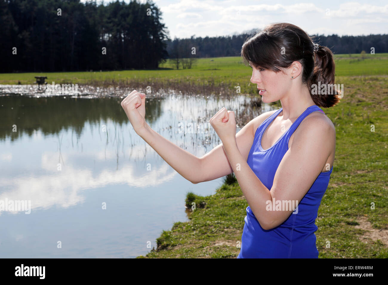 junge Frau, die an einem See und in Boxer-pose Stockfoto
