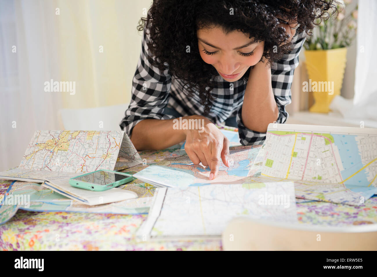 Gemischte Rassen Frau Planung Roadtrip mit Karten Stockfoto