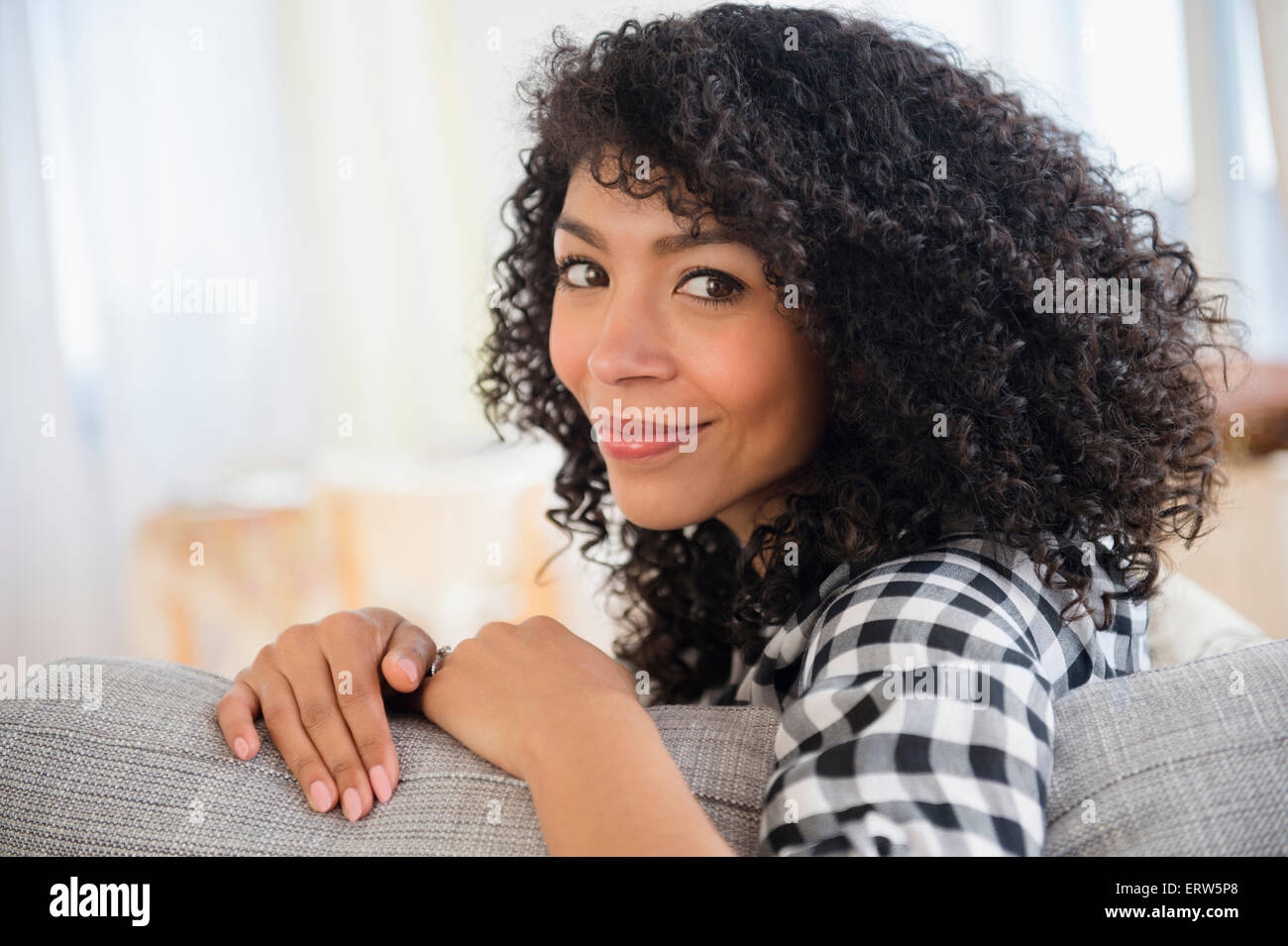 Gemischte Rassen Frau sitzend auf sofa Stockfoto