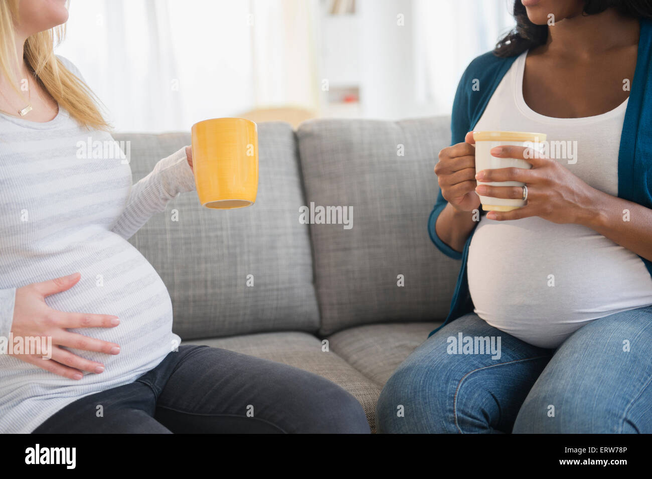 Schwangere Frauen Kaffee trinken und reden auf sofa Stockfoto