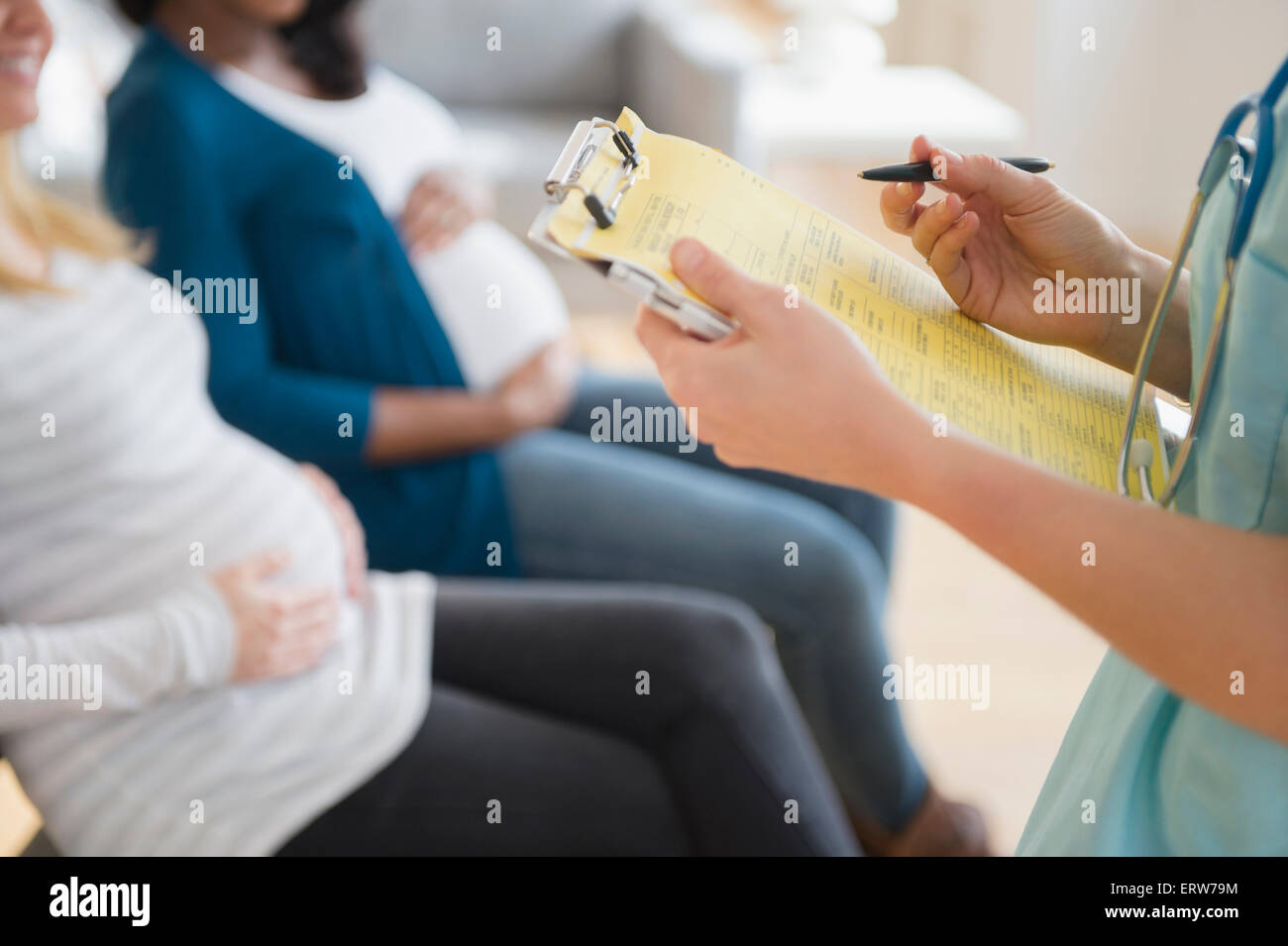 Krankenschwester Kennzeichnung medizinischen Diagramm in der Nähe von schwangeren Frauen Stockfoto