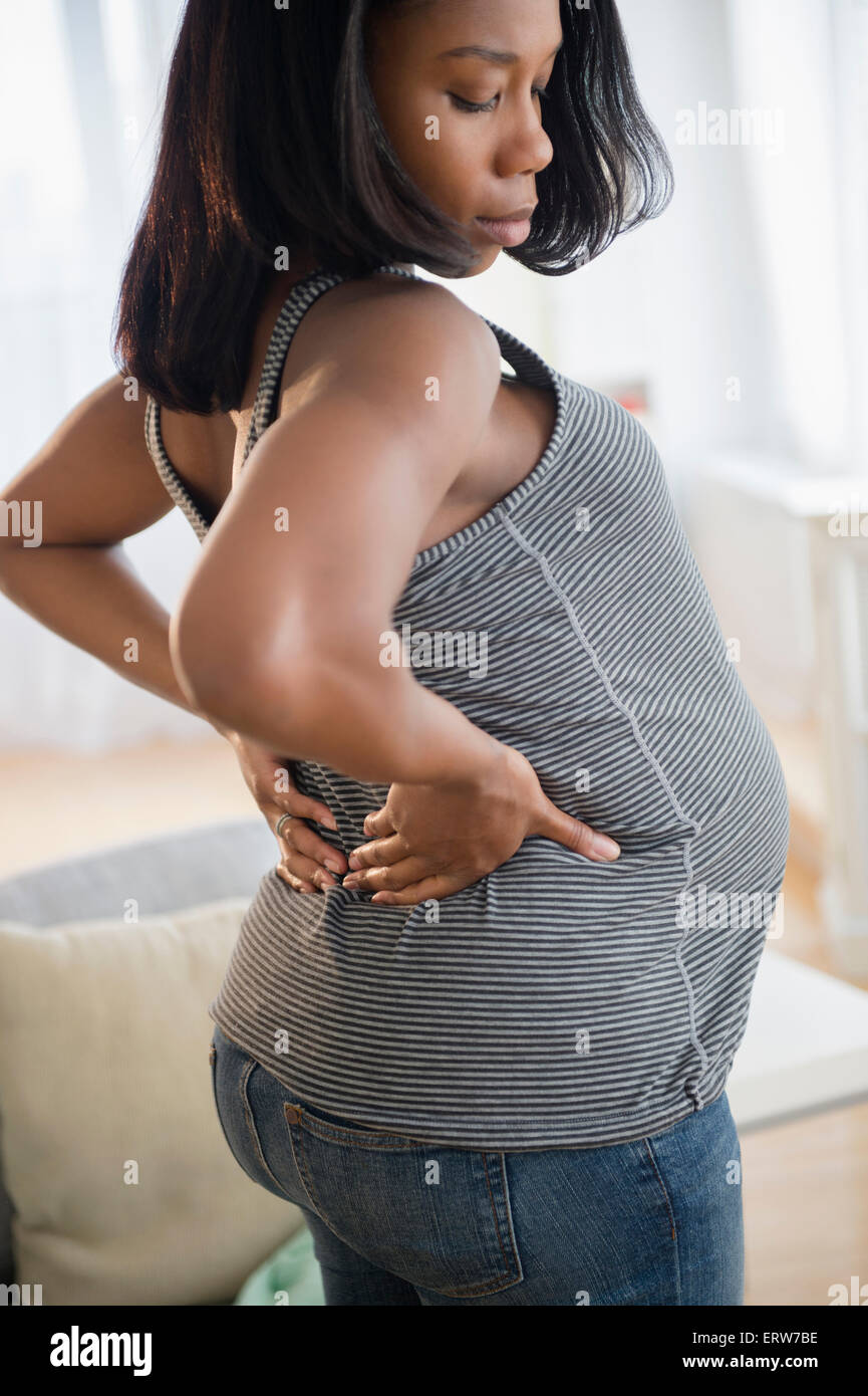 Schwarze schwangere Frau den Rücken dehnen Stockfoto