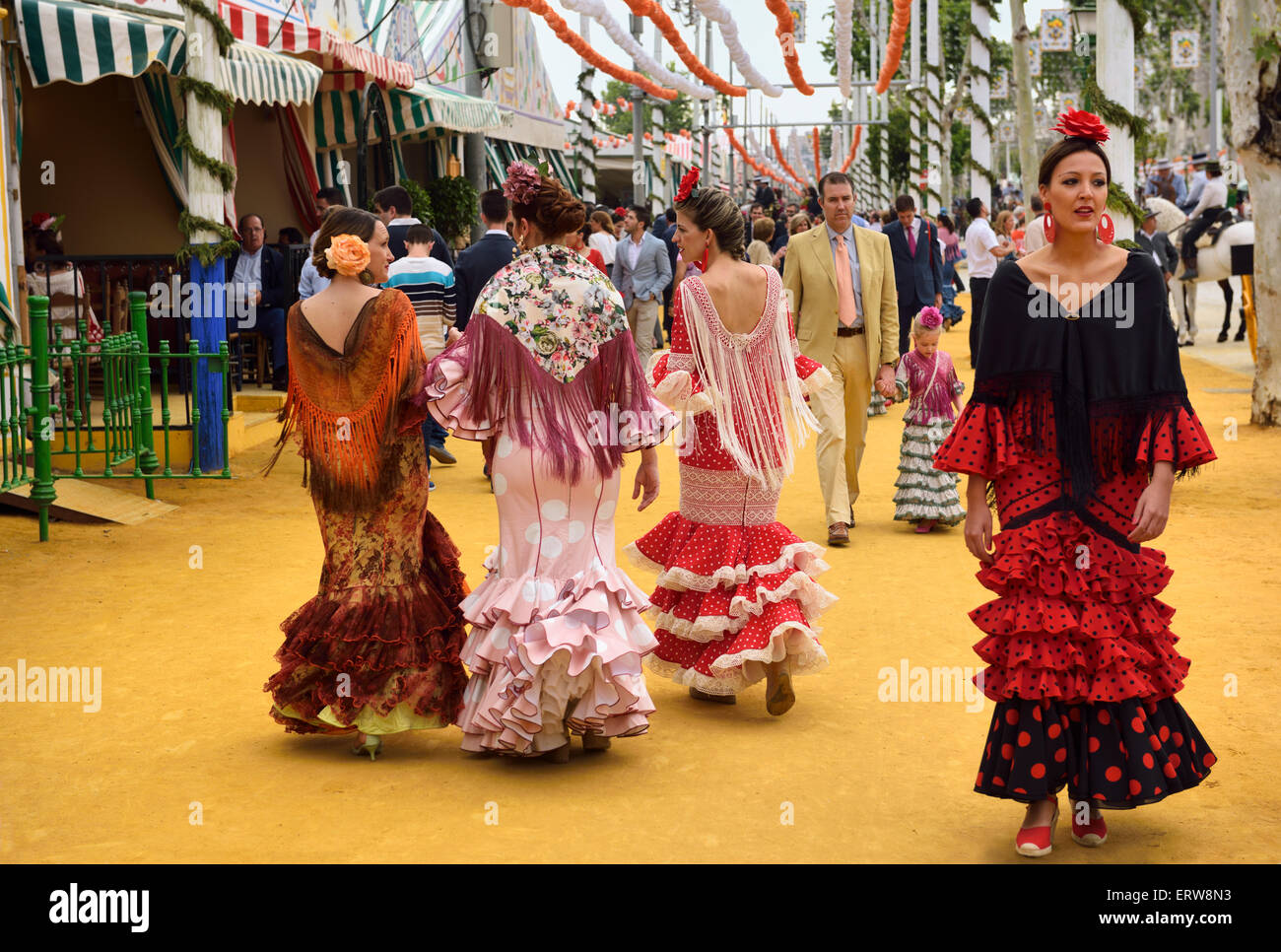 Frauen in Flamenco-Kleidern auf der ockerfarbenen Erde im April Fair in Sevilla Spanien Stockfoto