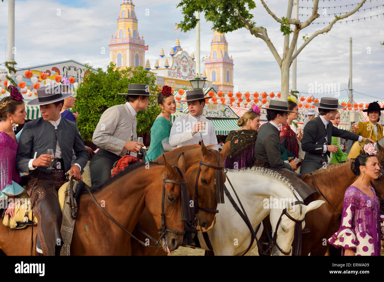 Gruppe von Paaren auf dem Pferderücken zu trinken und feiern auf der Sevilla-April-Messe mit Casetas und Main Gate Spanien Stockfoto