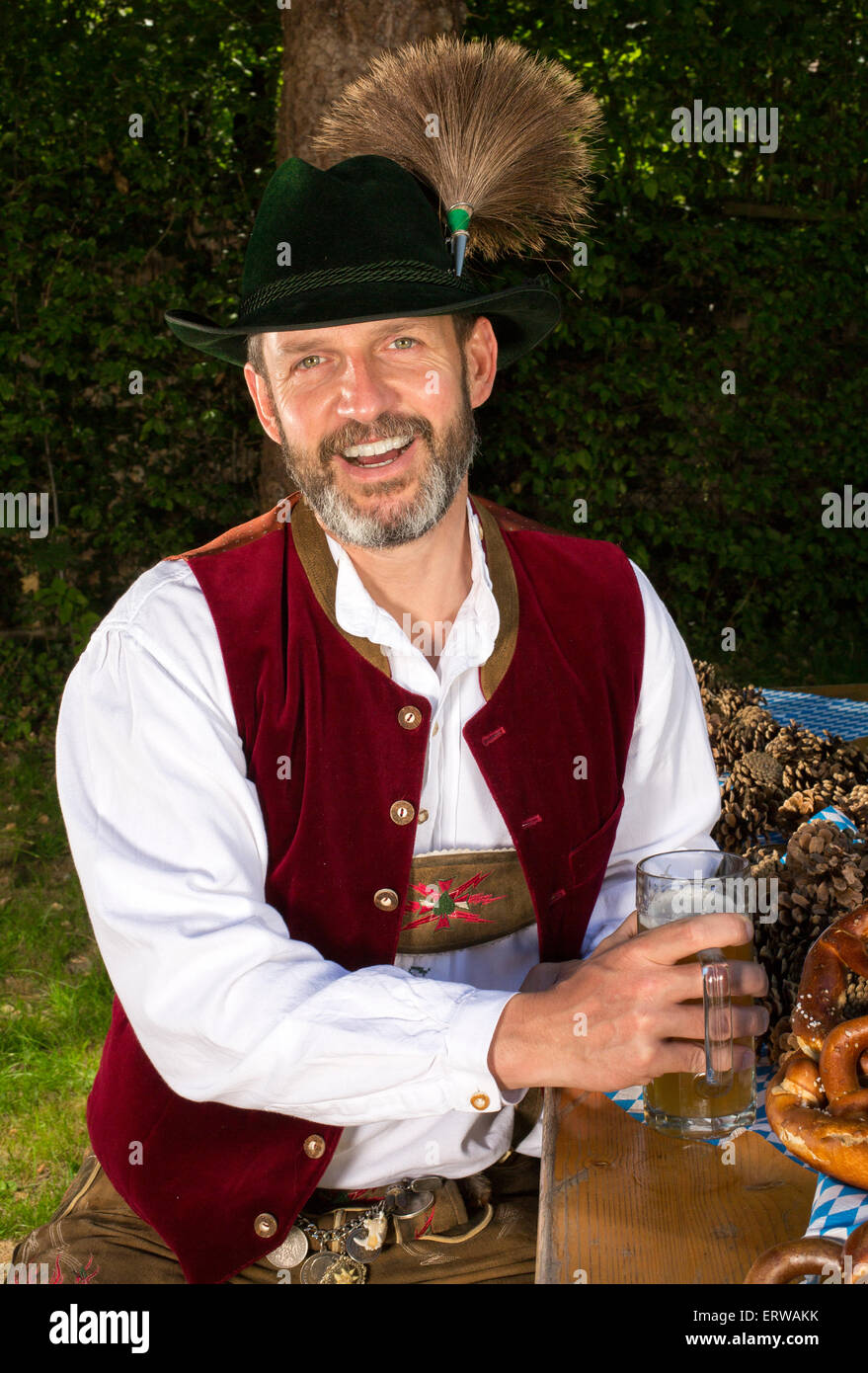 bayerischen Mann sitzt auf der Bank mit einem Bierkrug Stockfoto