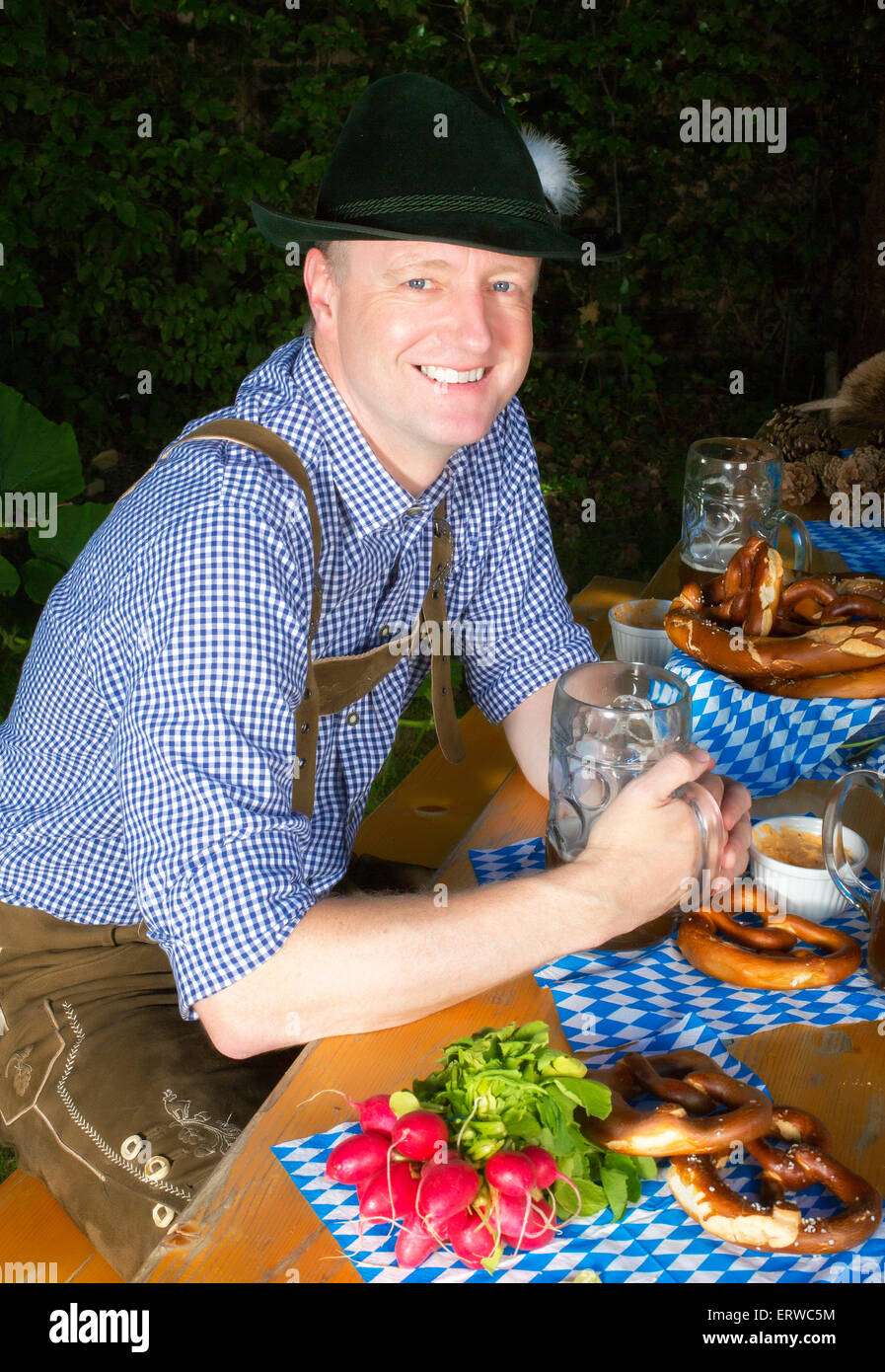 Mann in bayrischer Tracht in einem Biergarten sitzen Stockfoto