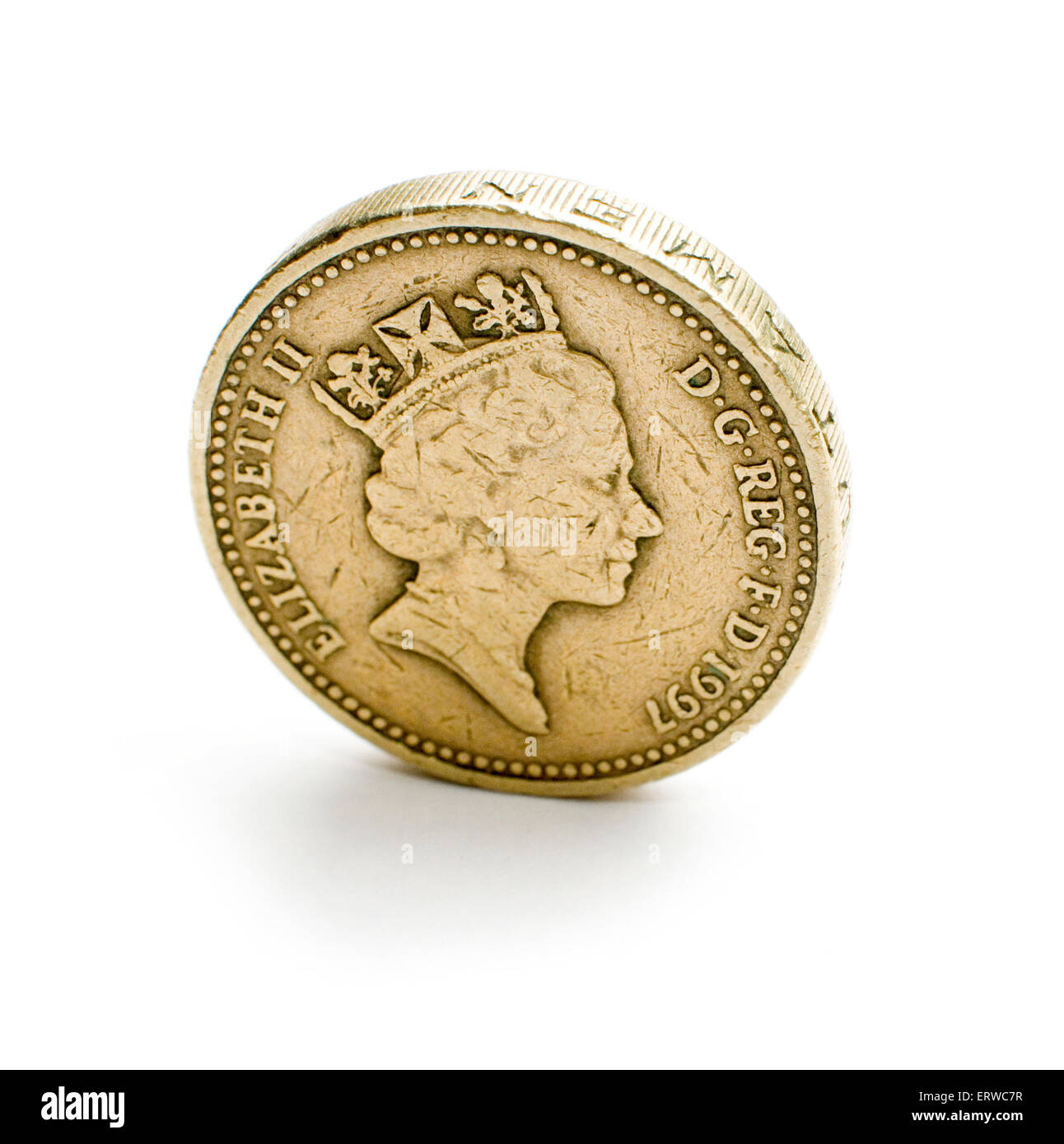 Einzelne Pfund-Münze am Rand - isoliert auf weiss. Stockfoto