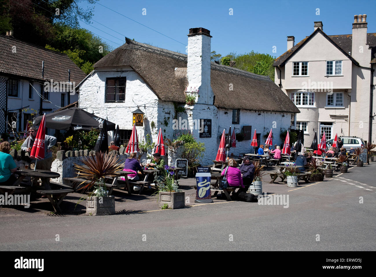 Das Ship Inn in Porlock Wehr Somerset mit Menschen saßen auf den sitzen auf Bänken, einen Drink in der Sonne Stockfoto
