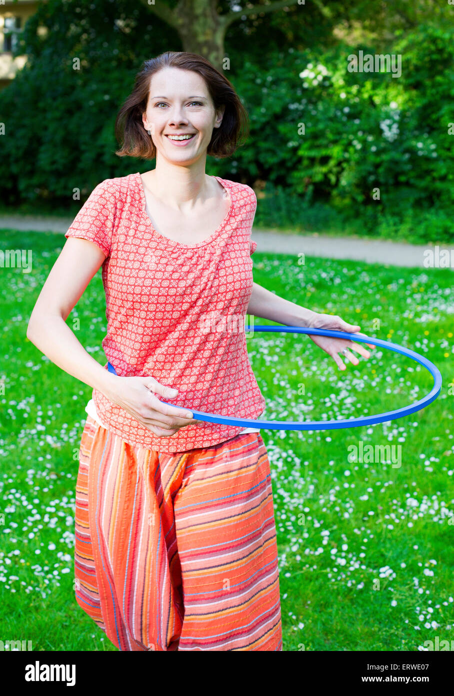 Frau im Park mit Hula-Hoop Stockfoto