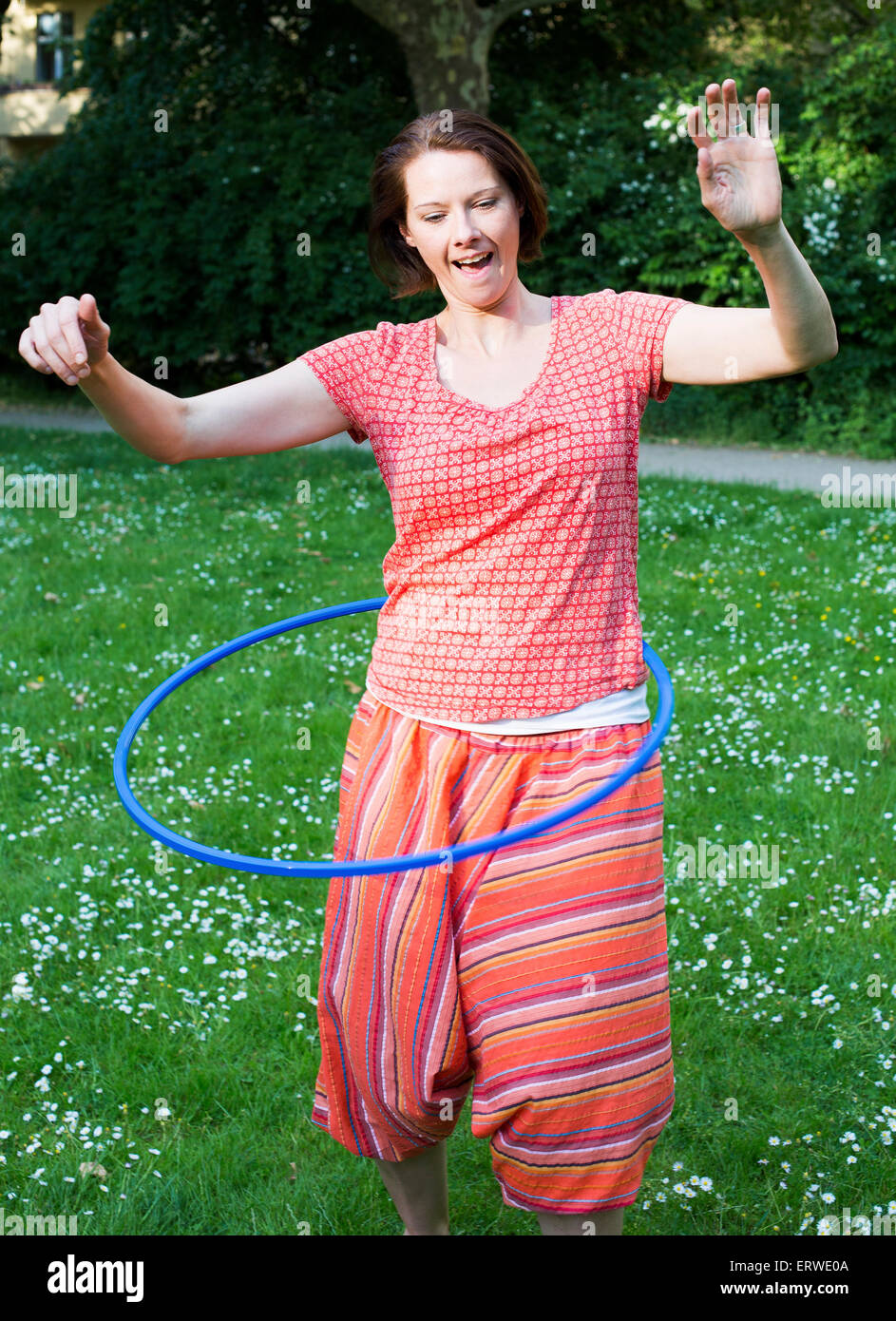 Frau im Park mit Hula-Hoop Stockfoto