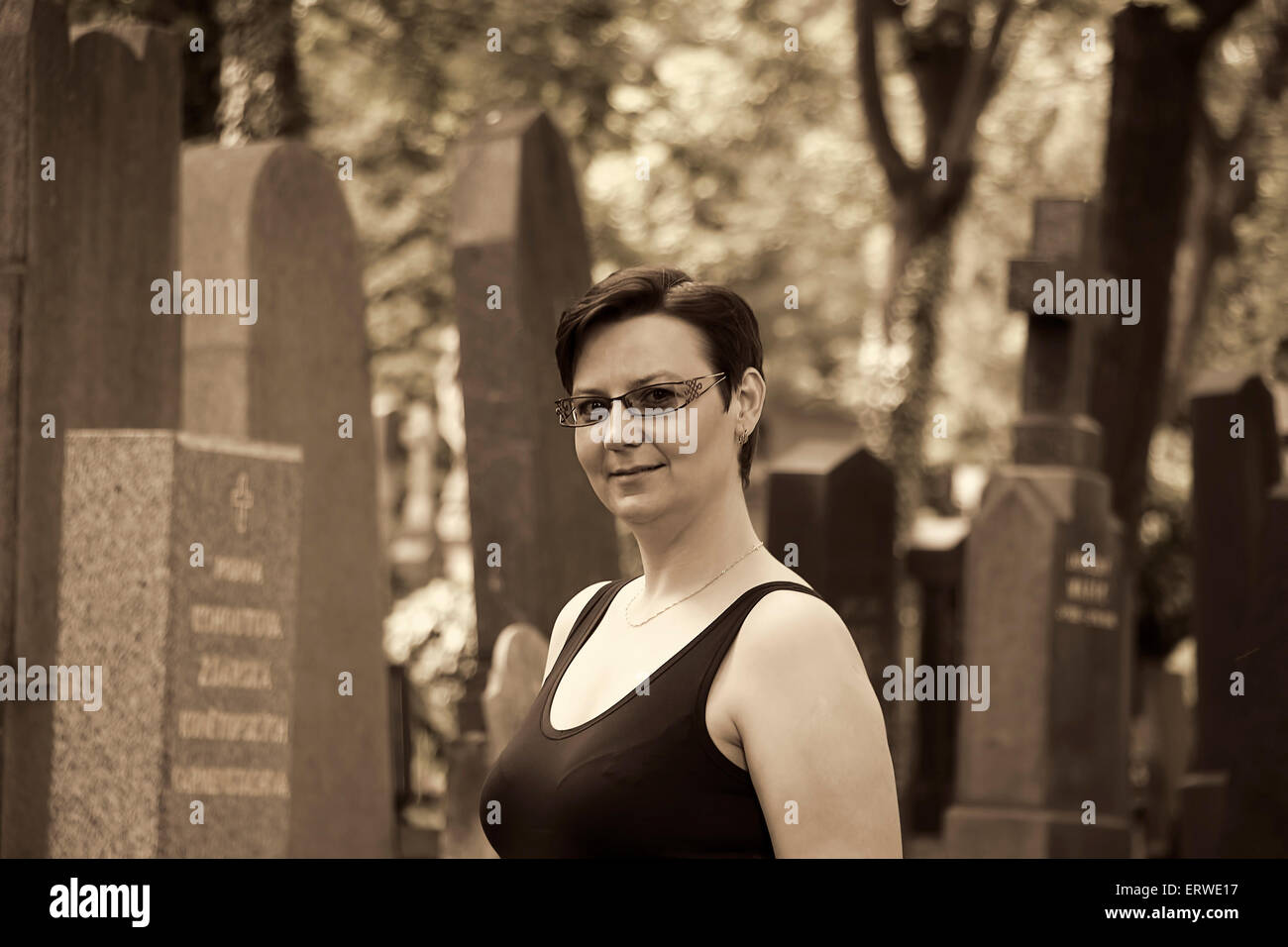 Porträt der jungen Frau auf einem Friedhof. Schwarz / weiß-Vintage-Look, melancholische Stimmung. Stockfoto