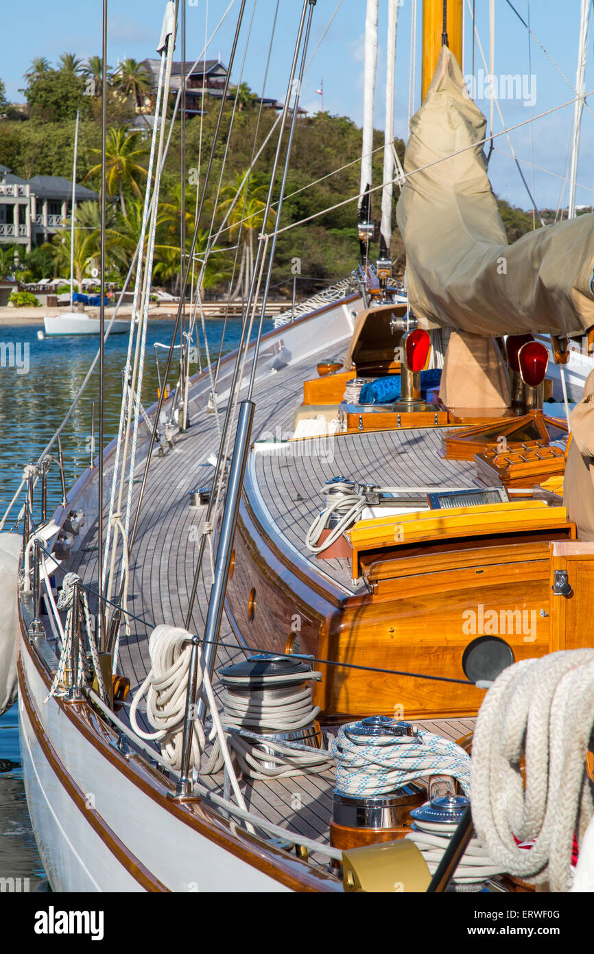 Klassische Yacht ankern in Falmouth, Antigua mit Villen im Hintergrund Stockfoto