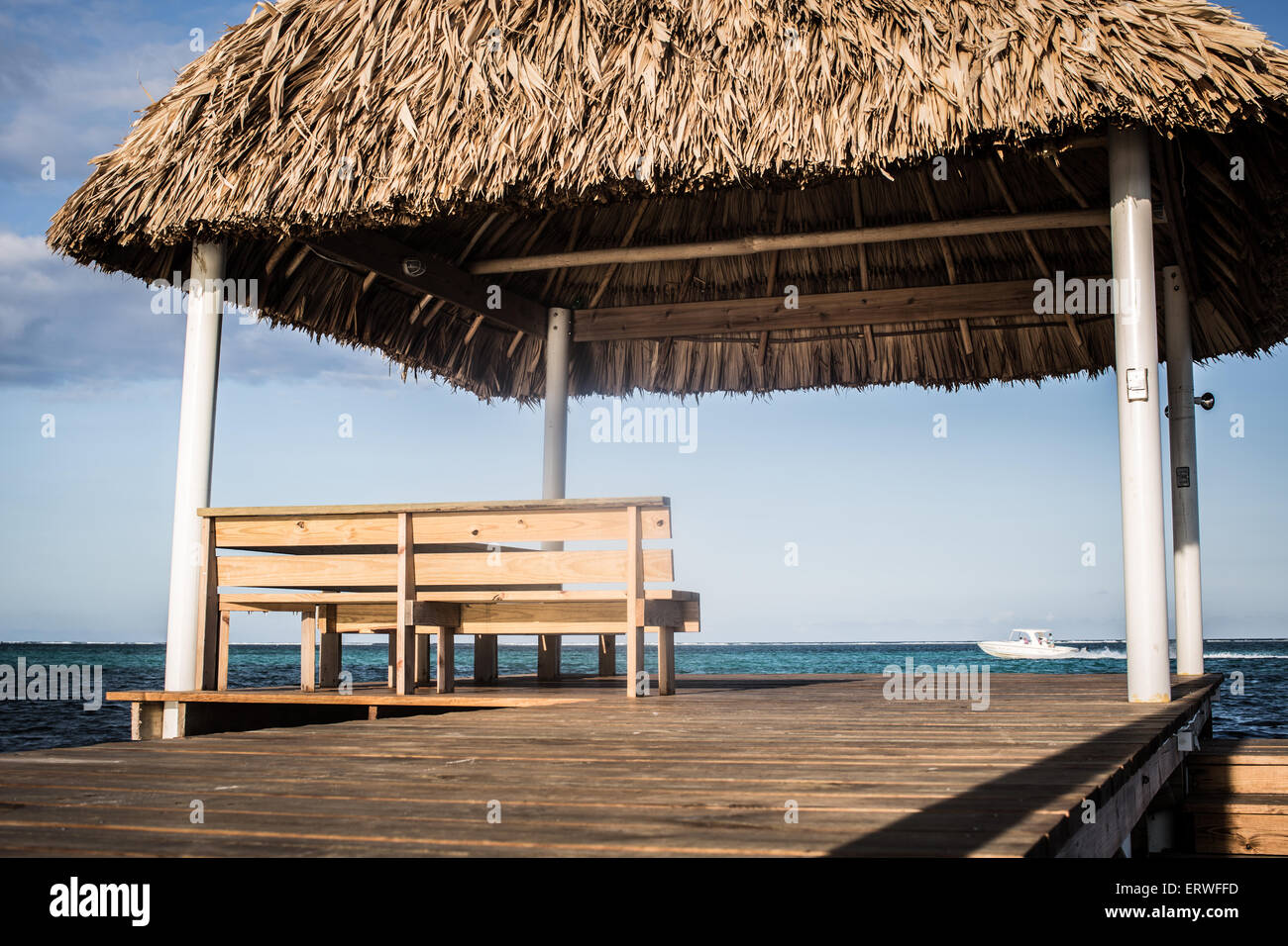 Eine karibische Sitzplatz mit Aussicht. Eine Palapa und die Bank zum Jahresende ein Dock mit Meerblick auf der Insel Ambergris Caye. Stockfoto