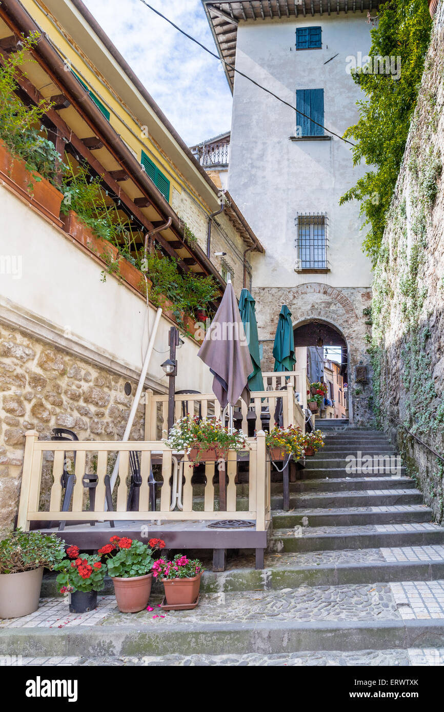 Alte steinerne Treppe mit Geländer in einer Straße in der Altstadt von einem Dorf in der Landschaft der Romagna Stockfoto