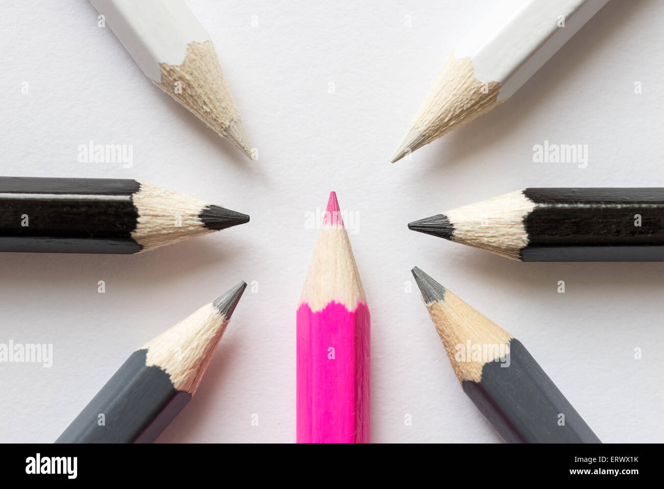 Rosa Bleistift umgeben von schwarzen, grauen und weißen Bleistifte Stockfoto