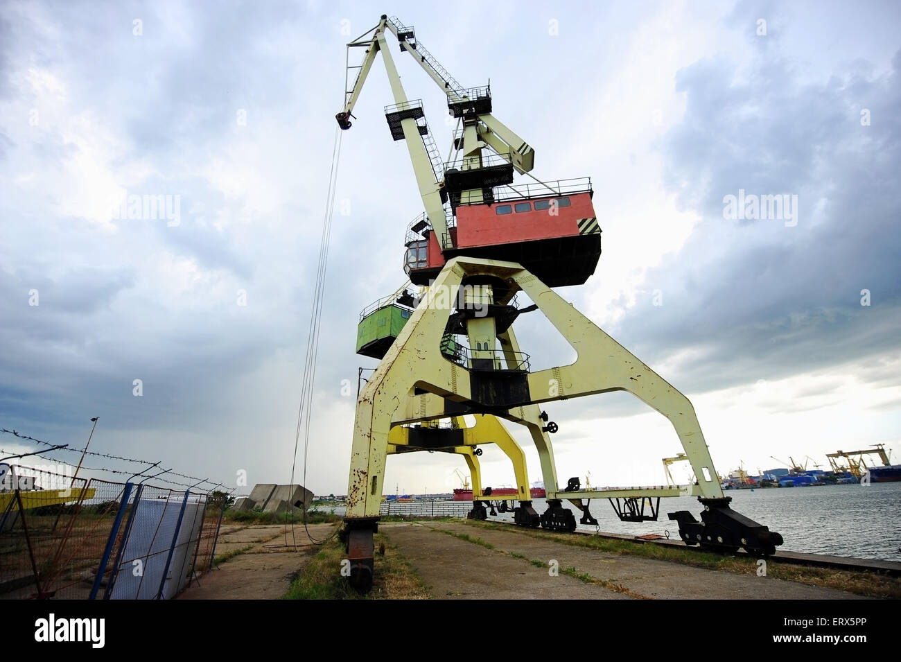 Industrielle Versand Krane für Container in einem Hafen mit dramatischer Himmel Hintergrund Stockfoto
