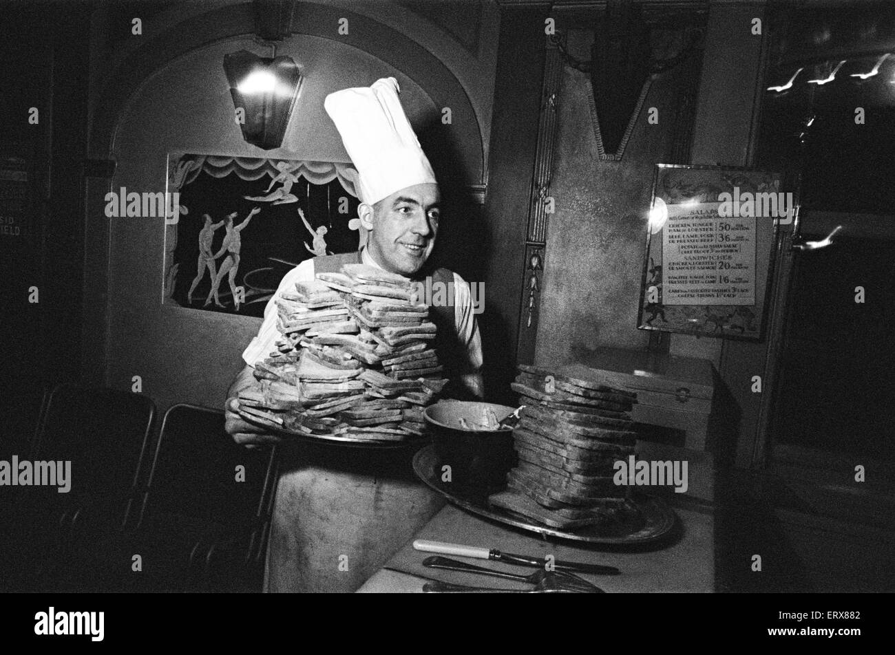 Ein Koch mit zwei riesigen Haufen von Toast. April 1947. Stockfoto