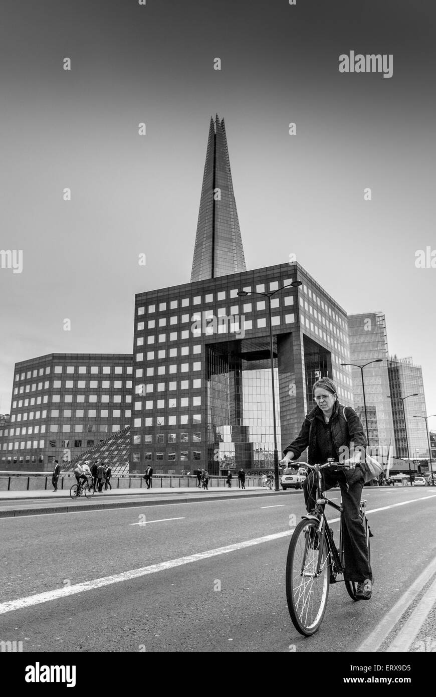 Radfahrer über London Brücke auf Fahrrad mit The Shard im Hintergrund, London, UK. Stockfoto