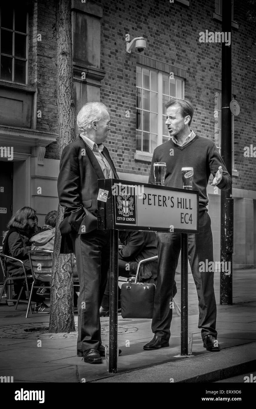 Zwei Männer, die eine mittags trinken und plaudern außerhalb, Peter Hill, London, UK. Stockfoto